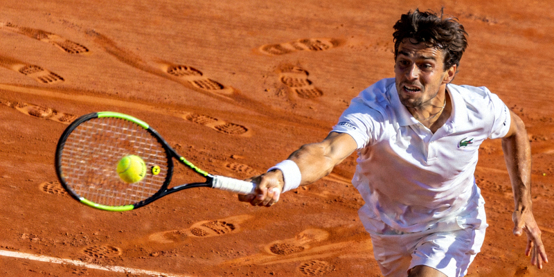 网球运动员在红土场上挥拍击球